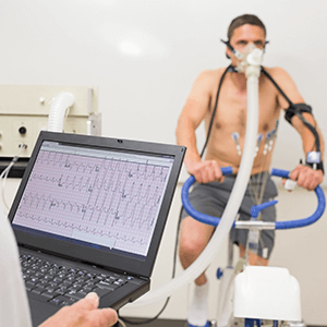 Person with breathing apparatus on exercise bike