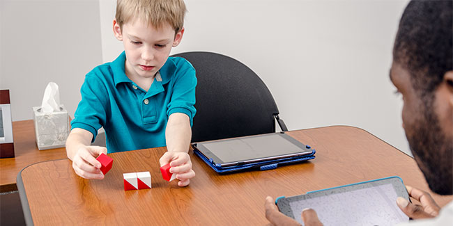 A man and a child do an activity with blocks.