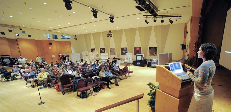 Woman giving a presentation on stage.