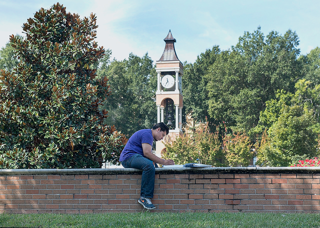 A pair of students appear to talk as they walk to class.