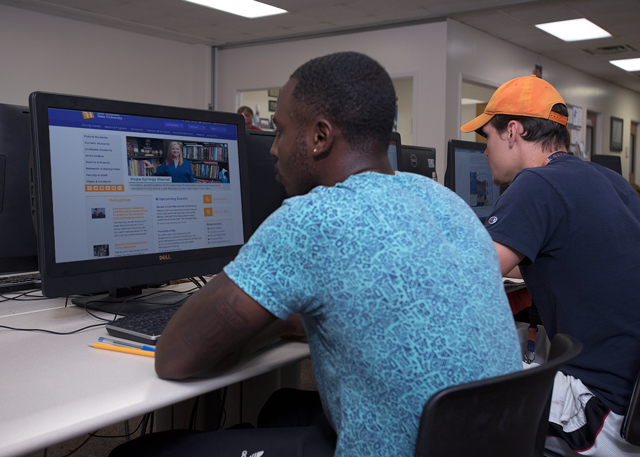 Student sitting at a computer in a computer lab.