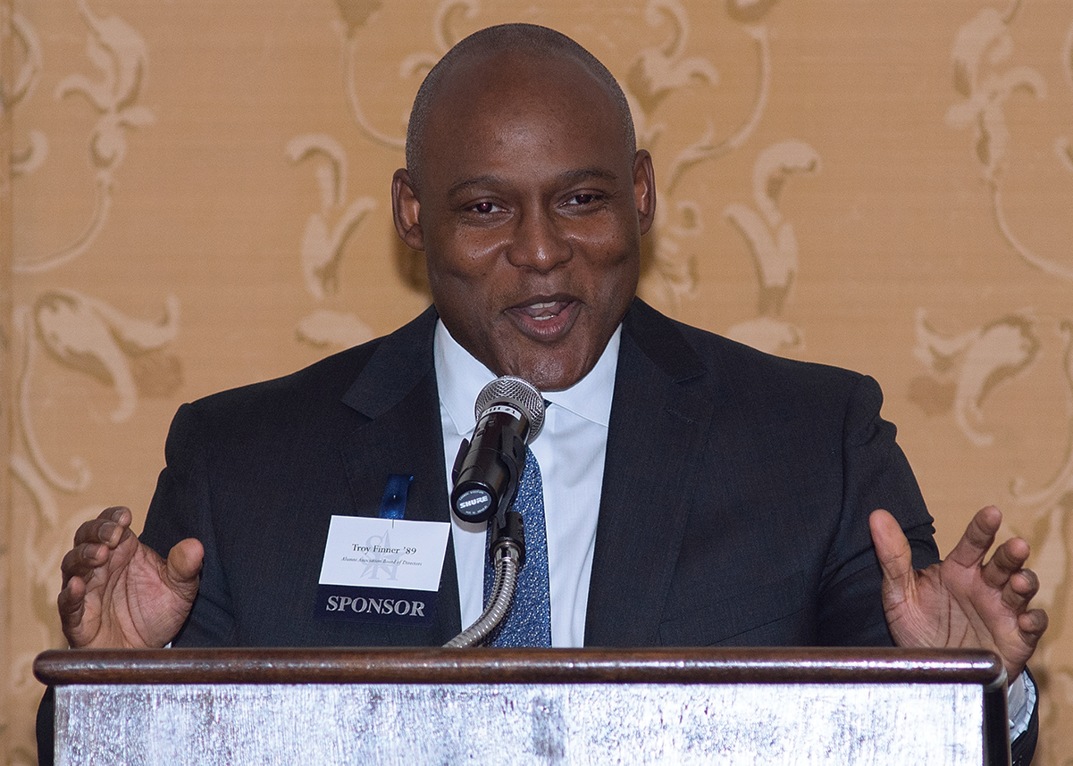 Troy Finner speaking at a podium in front of a microphone for a formal event. 